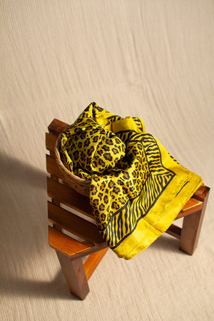 A yellow scarf with a leopard print and zebra stripe pattern 